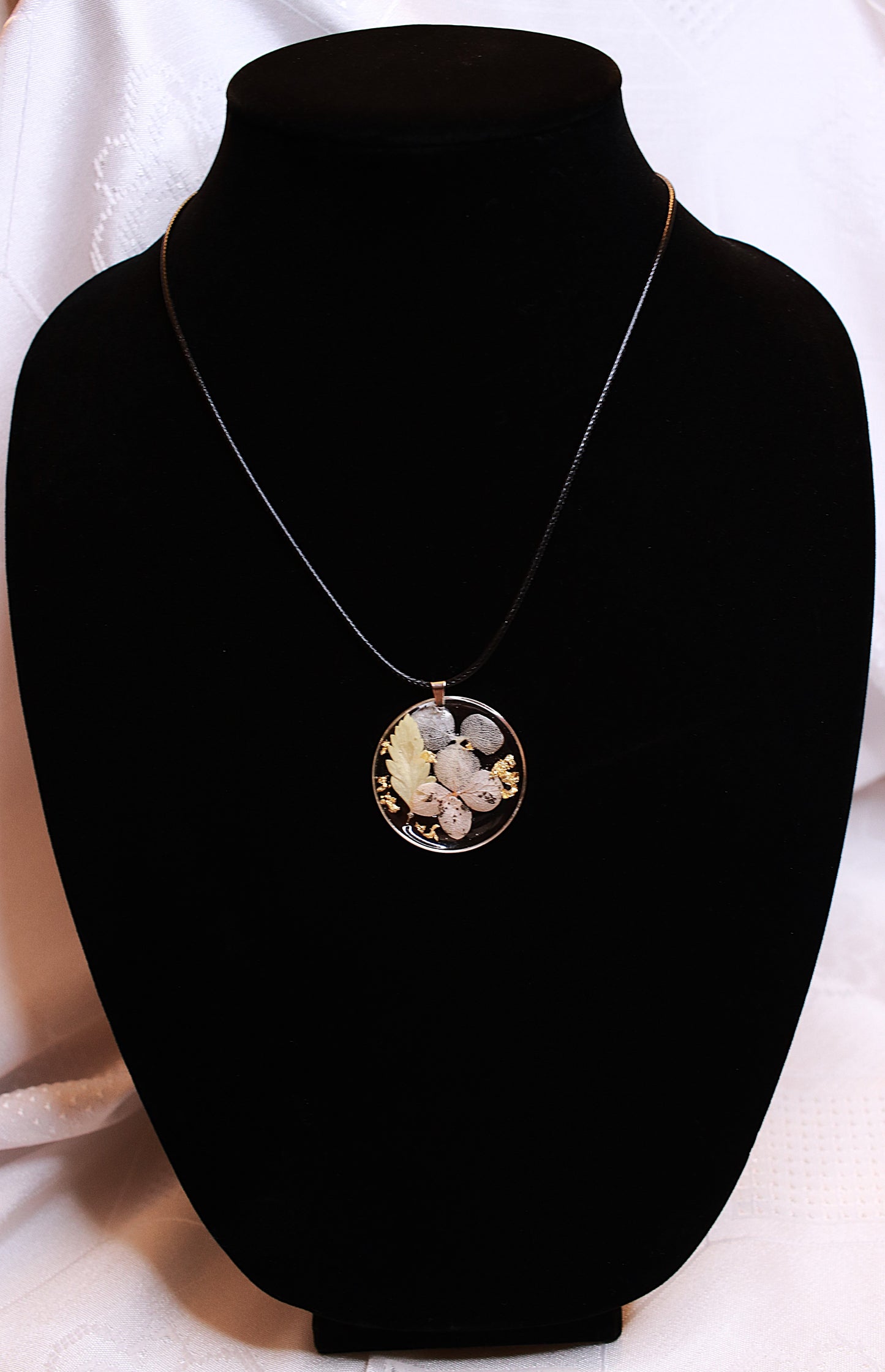 Round necklace featuring flowers with black rope